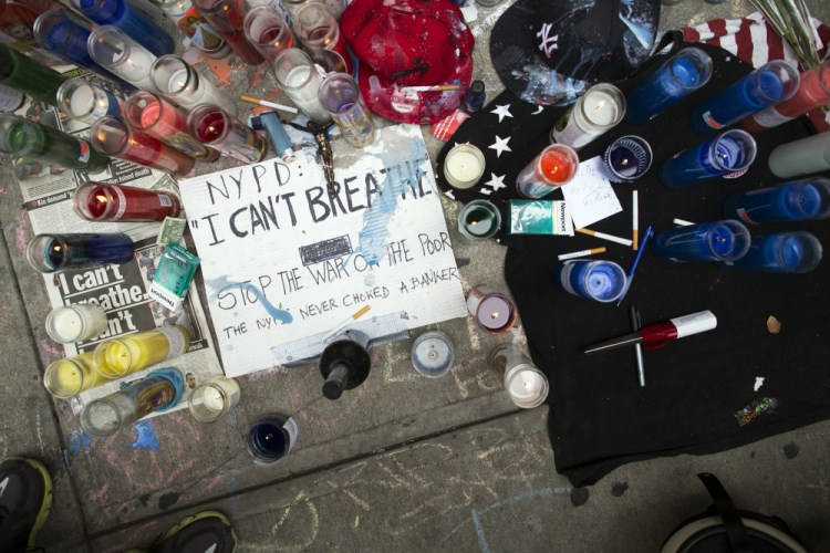 A memorial for Eric Garner rests on the pavement near the site of his death, July 19, 2014, in the Staten Island borough of New York.