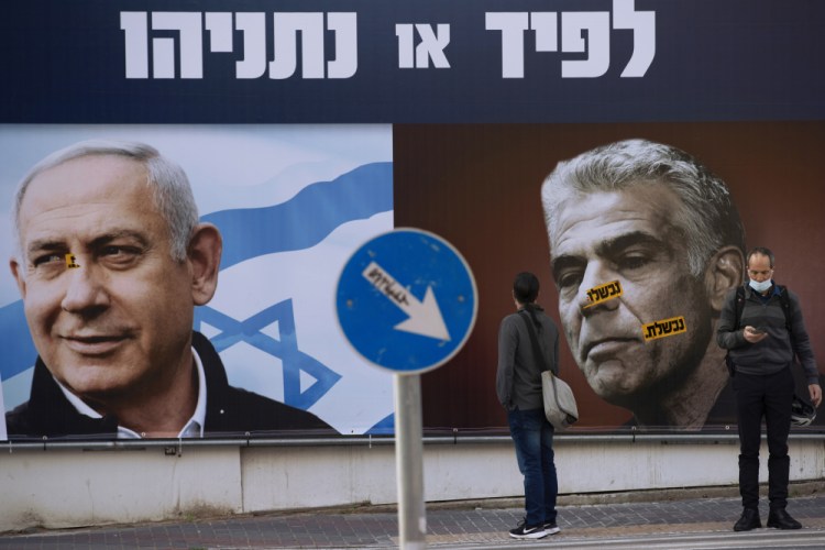 An election campaign billboard for the Likud party shows a portrait of its leader Prime Minister Benjamin Netanyahu, left, and opposition party leader Yair Lapid, in Ramat Gan, Israel,  in March. Israel’s President Reuven Rivlin has tapped Lapid to form a new government, a step that could lead to the end of Netanyahu’s lengthy rule. 
