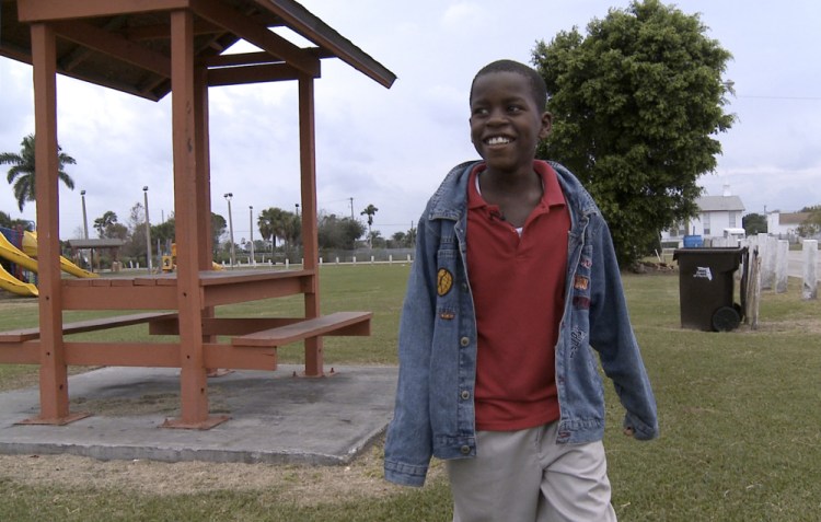 Then-10-year-old Damon Weaver walks in a park near his home in Pahokee, Fla., in 2009. Weaver who gained national acclaim when he interviewed President Barack Obama at the White House that year, has died of natural causes, his family says.   Lynne Sladky/Associated Press