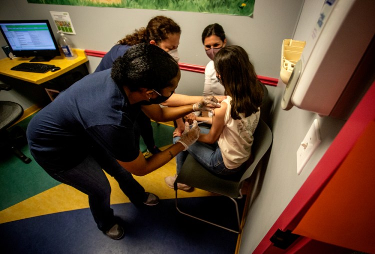 Middle school student Elise Robinson receives her first coronavirus vaccination on Wednesday in Decatur, Ga. Hundreds of children, ages 12 to 15, received the Pfizer vaccine at the DeKalb Pediatric Center, just days after it was approved for use within their age group.