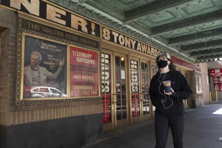 A woman walks past the Walter Kerr Theatre in New York City where "Hadestown" was showing before the pandemic forced its closing a year ago. The musical will return Sept. 2. 
