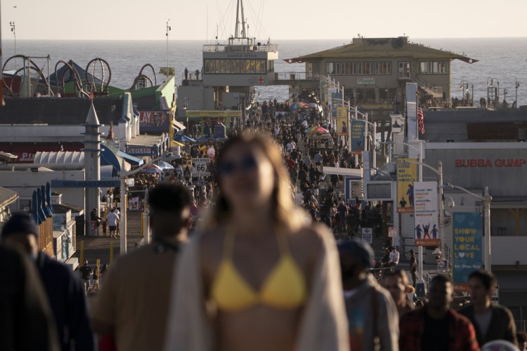 People crowd the Santa Monica Pier in Santa Monica, Calif. on April 7. Teams of experts are projecting COVID-19's toll on the U.S. will fall sharply by the end of July, according to research released by the government Wednesday, May 5. 