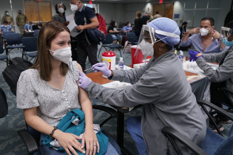 Natalia Dubom of Honduras gets the Johnson & Johnson COVID-19 vaccine at Miami International Airport on Friday. The vaccine was offered to all passengers arriving at the airport. Florida's Emergency Management Agency is running the program through Sunday.  
