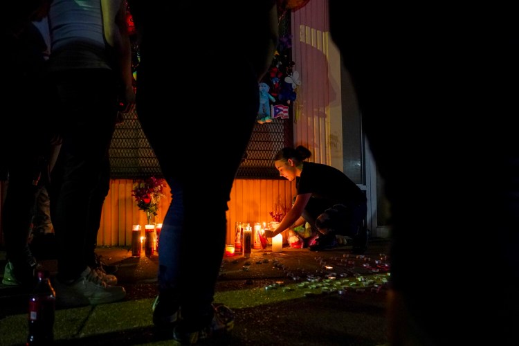 Autumn Piper lights candles during a vigil honoring Marcus Wilson, one of two men who were recently killed in the Highland town neighborhood of Baltimore in April. MUST CREDIT: Washington Post photo by Jahi Chikwendiu.