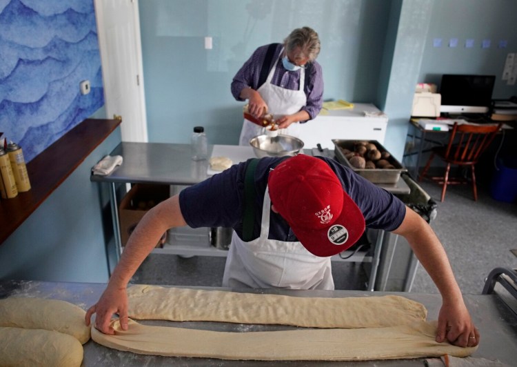 SOUTH PORTLAND, ME - MAY 25: Graeme Miller, owner of BenReuben's Knishery in South Portland, stretches out dough for knishes while his father Richard combines ingredients for rugelach on Tuesday, May 25, 2021. Miller opened the knishery, which he named after his father, in early May and uses recipes of his great grandmother as the basis for some of the knishes. (Staff photo by Gregory Rec/Staff Photographer)