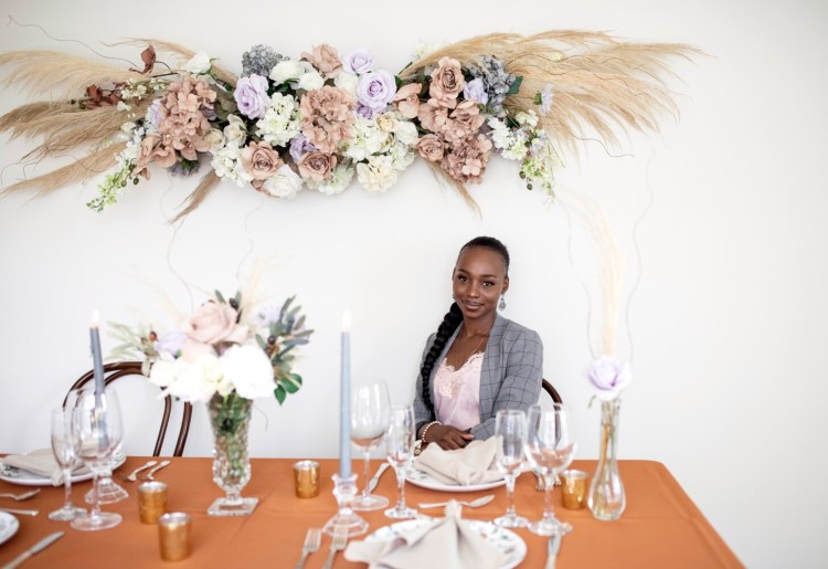 SOUTH PORTLAND, ME - JUNE 28: Deborah Bafongo poses for a portrait with a floral and table arrangement she created on Monday, June 28, 2021. Bafongo started her event design company, Angels of Love, in 2019 and was hoping 2020 would be the year her business really got off the ground. When the pandemic hit she applied for an interest-free loan which helped her compensate for losses from a lack of weddings last year. (Staff photo by Brianna Soukup/Staff Photographer)