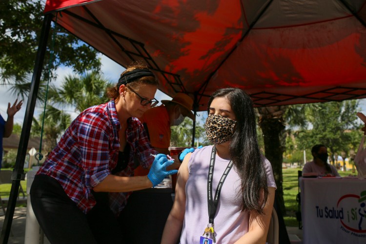 Danielle Gutierrez closes her eyes as city epidemiologist Michelle Jones administers her first dose of the Moderna COVID-19 vaccine for the City of Brownsville's Walk-Up COVID-19 Vaccine Clinic, Saturday, June 5, 2021, in Brownsville, Texas. (Denise Cathey/The Brownsville Herald via AP)