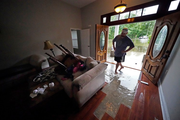 Danny Gonzales, walks in his flooded house as water recedes, after Tropical Storm Claudette passed through, in Slidell, La., Saturday, June 19, 2021.  The National Hurricane Center declared Claudette organized enough to qualify as a named storm early Saturday, well after the storm's center of circulation had come ashore southwest of New Orleans.(AP Photo/Gerald Herbert)