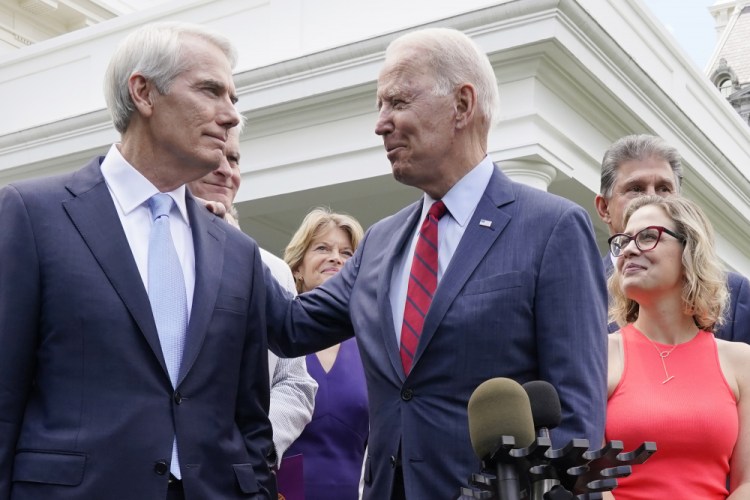 President Biden speaks with Sen. Rob Portman, R-Ohio, and others in a bipartisan group of senators, Thursday outside the White House in Washington.