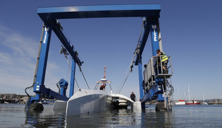 Technicians lower the so-called Mayflower Autonomous Ship into the water at its launch site for its first outing on water since being built in Turnchapel, England, in September 2020. The ship began a trans-Atlantic trip Tuesday, but the voyage was aborted when a mechanical problem developed.