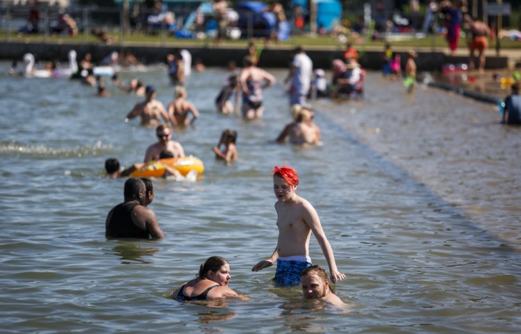 People try to cool off at a beach in Chestermere, Alberta, Canada, on Tuesday. Environment Canada warns the torrid heat wave that has settled over much of Western Canada won't lift for days. 