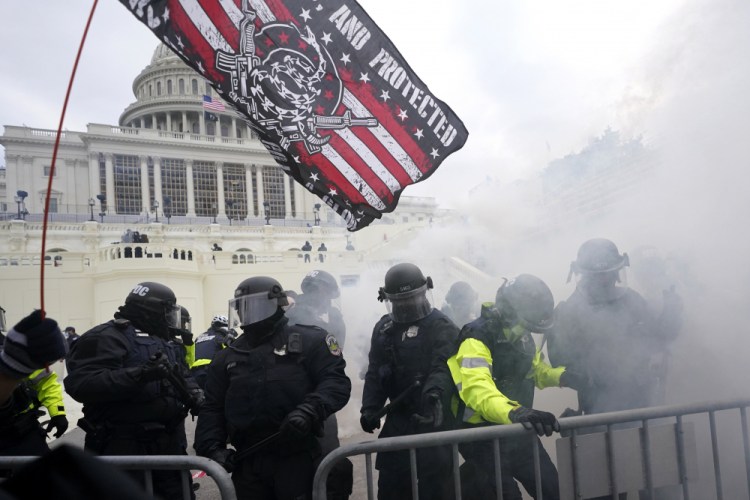 Police hold off supporters of Donald Trump who tried to break through a police barrier at the Capitol in Washington on Jan. 6.