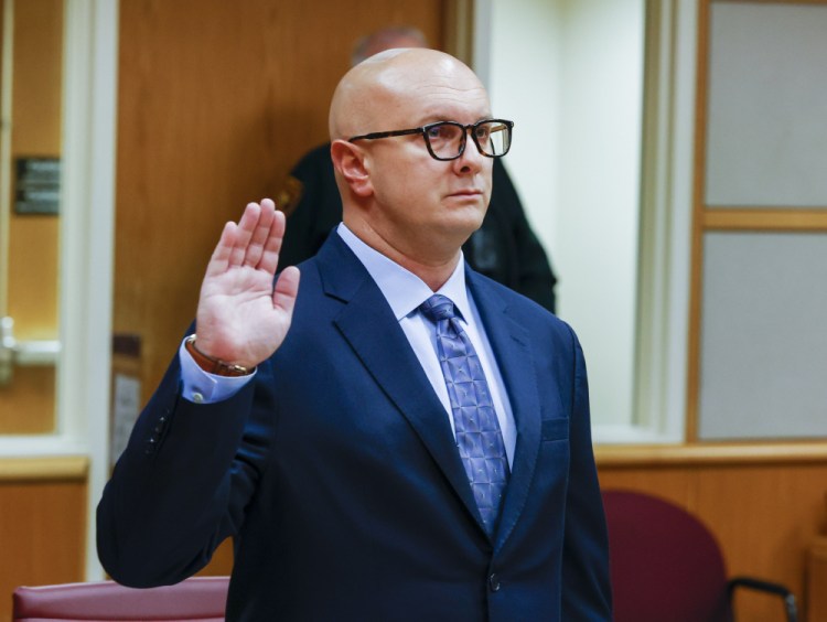William Braddock raises his hand to take an oath during a hearing Tuesday in Clearwater, Fla. Anna Paulina Luna, who plans to run for Florida's District 13 congressional seat, contends in court documents that Braddock is stalking her and wants her dead. Luna has filed a petition for a permanent restraining order.  Braddock denies the claims and wants to see any evidence against him. 