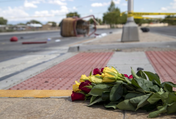 A bouquet of flowers from a mourner is placed near the basket of a hot air balloon which crashed in Albuquerque, N.M., on Saturday. All five occupants died. 