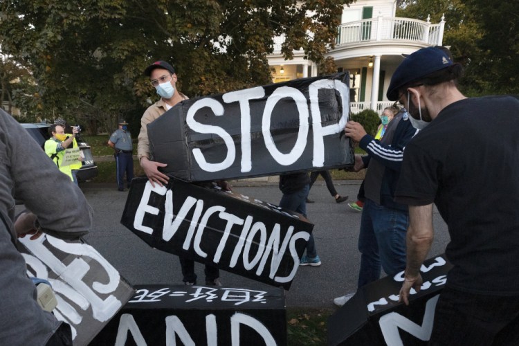 Housing activists erect a sign in Swampscott, Mass., in October. A federal freeze on most evictions is set to expire soon. 