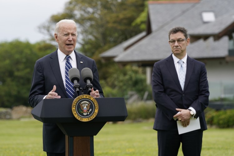 President Biden speaks about his administration's global COVID-19 vaccination efforts ahead of the G-7 summit, Thursday in St. Ives, England. Pfizer CEO Albert Bourla listens at right.