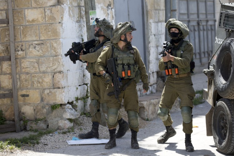 Israeli soldiers patrol after a soldier was killed when a rock thrown off a rooftop struck him in the head during an arrest raid, in the village of Yabad near the West Bank city of Jenin, in May 2020. The Israeli military says it is reining in a controversial practice of conducting late-night raids of Palestinian homes in the West Bank. 