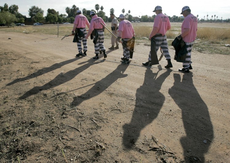 Members of the Maricopa County DUI chain gang are escorted to their assignment in Phoenix in 2007. As the nation on Thursday, June 17, 2021 officially made Juneteenth a federal holiday, honoring when the last enslaved Black people learned they were free, lawmakers are reviving calls to end a loophole in the Constitution that has allowed another form of slavery to thrive. 