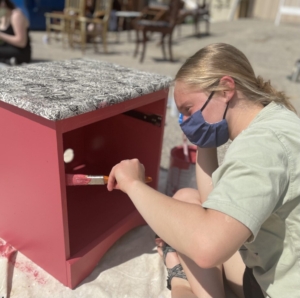 Kennebunk High School senior Phebe Grant paints a cabinet to be sold at Habitat of Humanity York County's Re-Store as part of a senior project.jpg