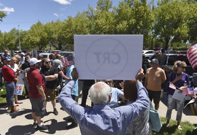 A man holds up a sign against Critical Race Theory during a protest outside a Washoe County School District board meeting on May 25 in Reno, Nev.