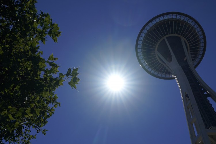 The sun shines near the Space Needle, Monday, June 28, 2021, in Seattle. 