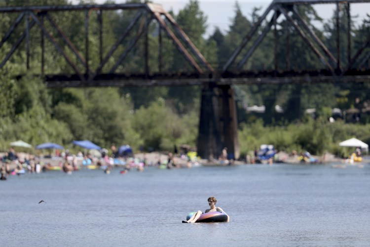 People gather at the Sandy River Delta in Oregon to cool off during the start of what should be a record-setting heat wave on Friday. 

