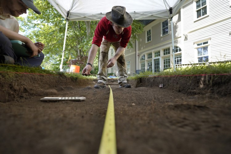 University of Massachusetts Boston graduate students Sean Fairweather, of Watertown, Mass., left, and Alex Patterson, of Quincy, Mass., right, use measuring instruments while mapping an excavation site Wednesday on Cole's Hill in Plymouth, Mass. 