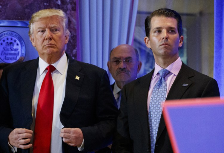 This Jan. 11, 2017, shows President-elect Donald Trump, left, his chief financial officer Allen Weisselberg, center, and his son Donald Trump Jr., right.
