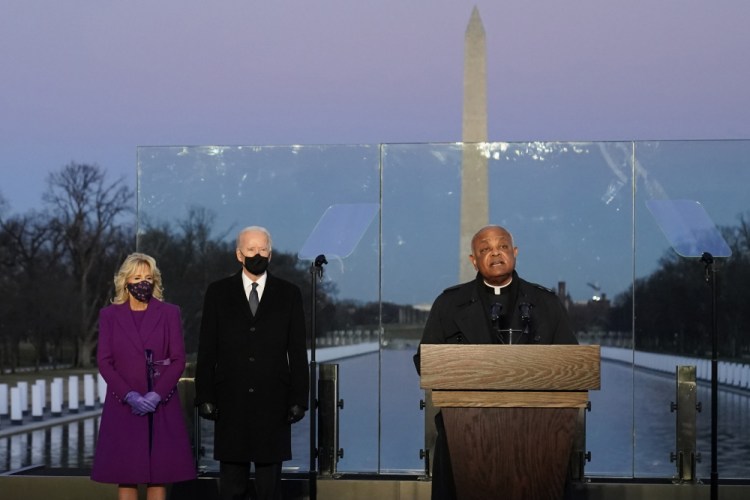 In January, then President-elect Joe Biden and his wife, Jill, listen as Cardinal Wilton Gregory, Archbishop of Washington delivers the invocation during a COVID-19 memorial at the Lincoln Memorial Reflecting Pool in Washington. Gregory has made clear that Biden, who sometimes worships in Washington, is welcome to receive Communion at the archdiocese's churches. 