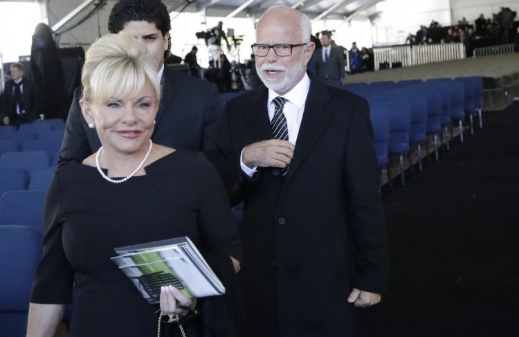 Televangelist Jim Bakker, right, walks with his wife Lori Beth Graham after a funeral service at the Billy Graham Library for the Rev. Billy Graham, in Charlotte, N.C. in 2018. Jim Bakker and his southwestern Missouri church will pay restitution of $156,000 to settle a lawsuit that accused the TV pastor of falsely claiming that a health supplement could cure the coronavirus. 