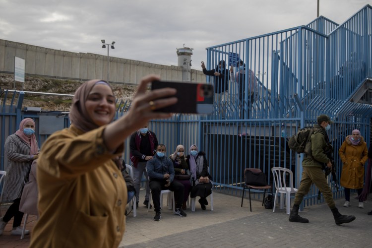Palestinians take a selfie after receiving the coronavirus vaccine from an Israeli medical team at the Qalandia checkpoint between the West Bank city of Ramallah and Jerusalem in February.