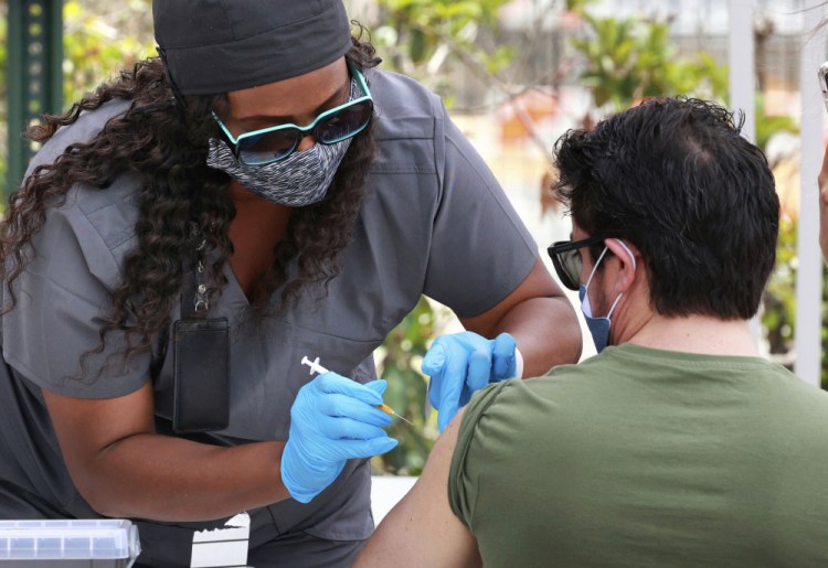 An Orange County resident receives the COVID-19 vaccine at a mobile vaccination site at Camping World Stadium in Orlando, Fla., on Thursday. U.S. demand for shots has slumped.