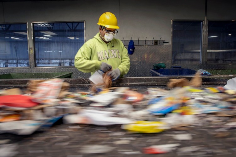 Alam Jahanger sorts recycling at Ecomaine on April 10, 2020. Maine’s recycling market has rebounded after years of losing money.