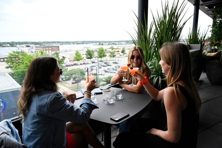 PORTLAND, ME - JULY 1: L to R: Hannah Duffek, Page Tetu and Allison Hill all of Brunswick have drinks together at Luna Rooftop Bar at Canopy Portland Waterfront Hotel Thursday, July 1, 2021. (Staff Photo by Shawn Patrick Ouellette/Staff Photographer)