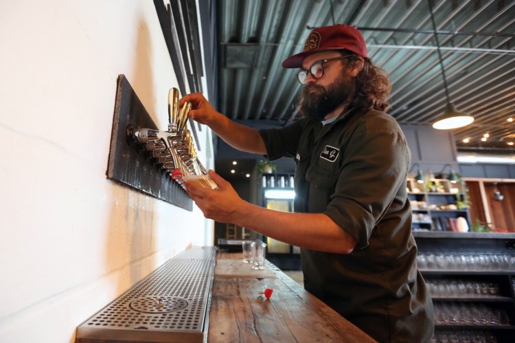 PORTLAND, ME - JULY 12: Ian Goering, head of production at Apres, 148 Anderson St., Portland, draws a glass of hard seltzer from a tap. (Staff photo by Ben McCanna/Staff Photographer)