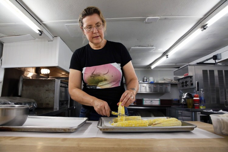 NEW GLOUCESTER, ME - JULY 15: Krista Desjarlais of Bresca & the Honeybee cuts kernels from the cob to make summer corn semifreddo with a blueberry compote. (Staff photo by Ben McCanna/Staff Photographer)