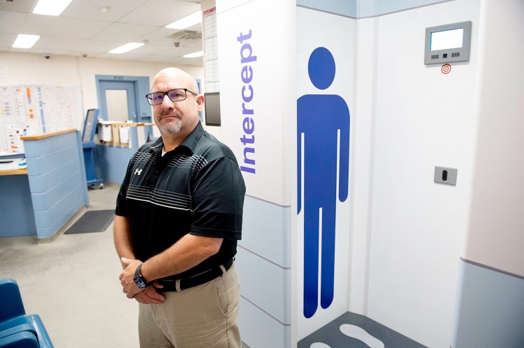 Androscoggin County Jail Administrator Jeff Chute stands Thursday next to the full body scanner that detects drugs, weapons and other contraband on inmates and incoming packages at the facility in Auburn.