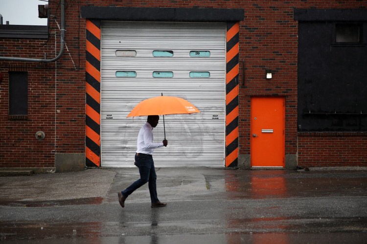 A man walks in the rain on Danforth Street in Portland on Tuesday. 