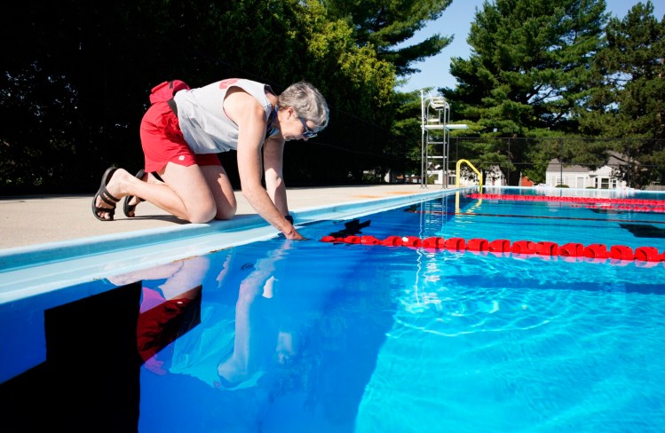 Barbara Linnehan-Smith disconnects a lane divider at the Kiwanis Pool in Portland on Friday. She has been a lifeguard for 50 years.