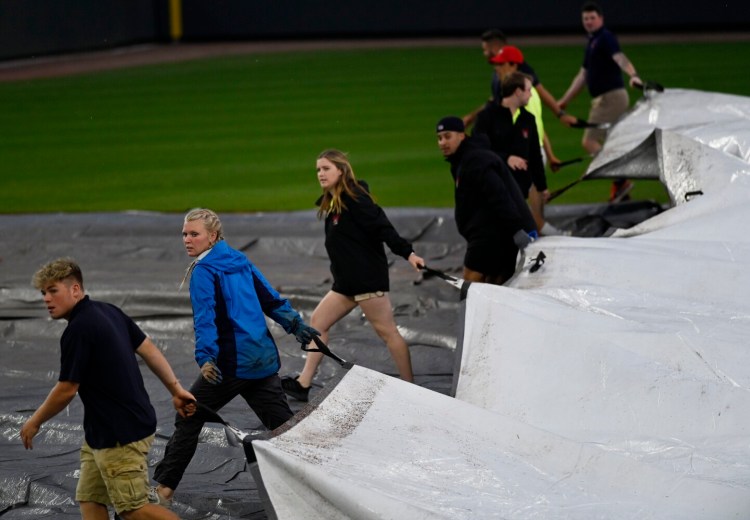 The grounds crew rolls out the tarps shortly before the rain began to fall before the start of the Sea Dogs game against New Hampshire Fisher Cats last Tuesday in Portland. The game was rained out.