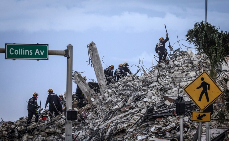 Rescuers search for victims at a collapsed South Florida condo building Monday, July 5, 2021, in Surfside, Fla., after demolition crews set off a string of explosives that brought down the last of the Champlain Towers South building in a plume of dust on Sunday. (Carl Juste/Miami Herald via AP)
