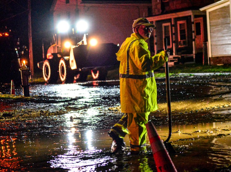 Crews clean up mud and debris in Bellows Falls, Vt., after flooding from a storm that dumped several inches of rain on Thursday. 