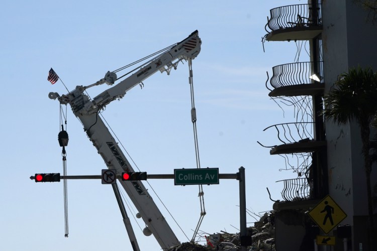 A crane next to the Champlain Towers South condo building, where scores of victims remain missing more than a week after it partially collapsed, Sunday in Surfside, Fla. 