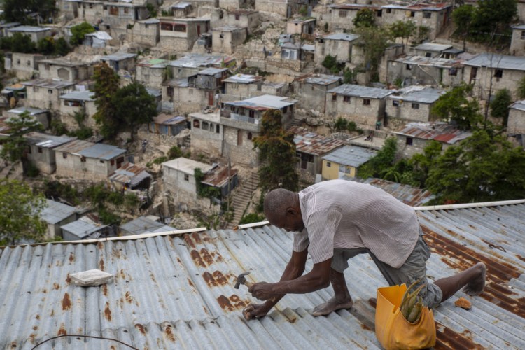 Antony Exilien secures the roof of his house in response to Tropical Storm Elsa, in Port-au-Prince, Haiti, on Saturday. Elsa brushed past Haiti and the Dominican Republic on Saturday and threatened to unleash flooding and landslides before taking aim at Cuba and Florida. 