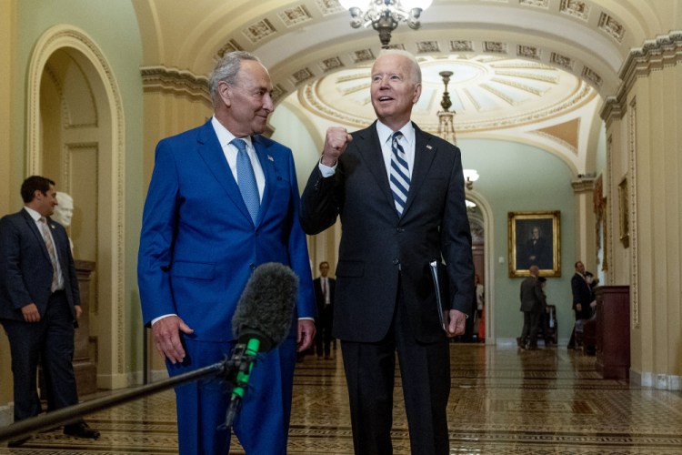 President Biden speaks to members of the media as he stands with Senate Majority Leader Chuck Schumer, D-N.Y., at the Capitol in Washington on Wednesday.