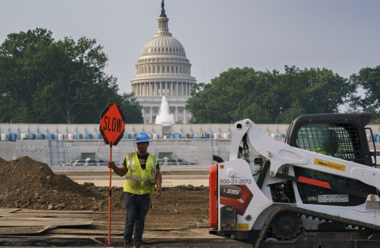 Workers repair a park near the Capitol in Washington on Wednesday as senators struggle to reach a compromise over how to pay for nearly $1 trillion in public works spending, a key part of President Biden's agenda. 