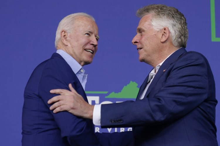 President Biden greets Virginia Democratic gubernatorial candidate Terry McAuliffe as he arrives to speak at a campaign event for McAuliffe at Lubber Run Park Friday in Arlington, Va.