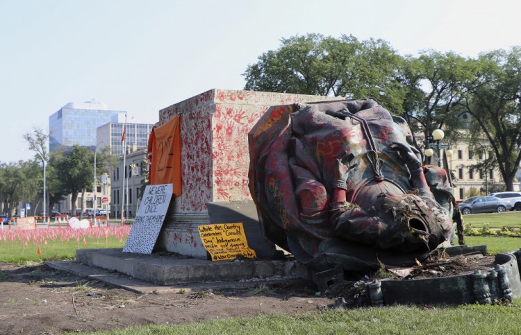 A headless statue of Queen Victoria is seen overturned and vandalized at the provincial legislature in Winnipeg, Manitoba, on Friday. Her statue and a statue of Queen Elizabeth II were toppled on Canada Day during demonstrations concerning Indigenous children who died at residential schools.  