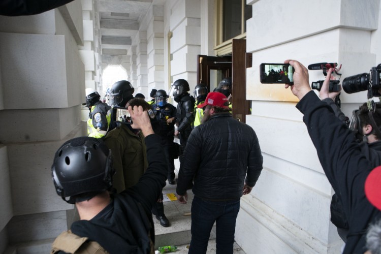 People record as Capitol Police officers push back violent insurrectionists loyal to President Donald Trump at the U.S. Capitol in Washington on Jan. 6. 

