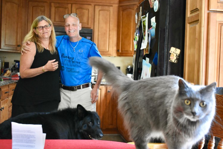Shari and Dan Campbells' dog and cat want in on the picture at their home in Auburn on Saturday.